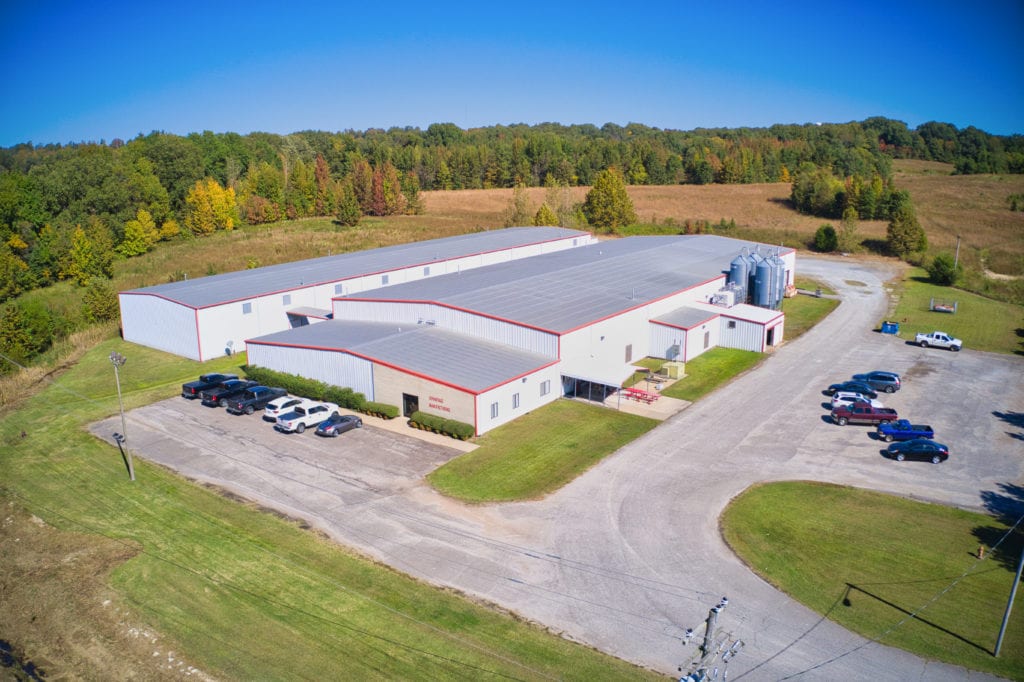 Arial view of the Advantage Manufacturing factory and facility with parking lot, cars, fields, and trees in Friendship, TN